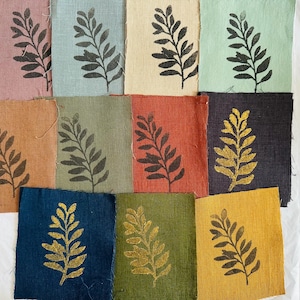 Peut inclure: Dix carrés de tissu avec un motif de feuille imprimé dessus. Les carrés sont de différentes couleurs, notamment rose, bleu, vert, marron, rouge, noir et or.