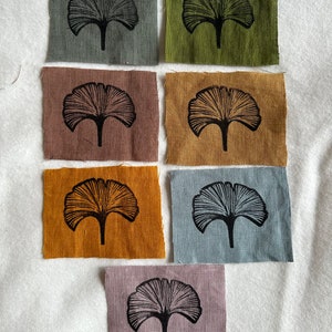 May include: Six fabric squares with a black ginkgo leaf print. The squares are in various colors, including green, brown, orange, blue, and purple.