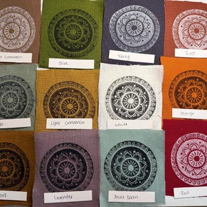May include: A collection of fabric swatches in various colors, each featuring a circular mandala design in a contrasting color. Colors include rust, navy, true cinnamon, olive, orange, sage, light cinnamon, white, mustard, lavender, mint green, and red.