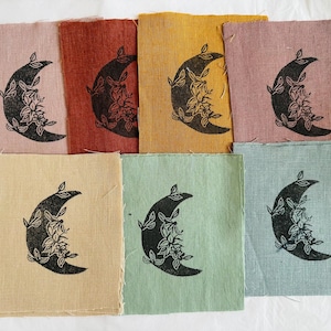 Peut inclure: Ensemble de huit carrés de tissu avec un motif de croissant de lune noir imprimé sur chacun. Les carrés sont de différentes couleurs, notamment rose, rouge, jaune, vert et bleu.