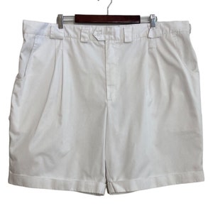 May include: White pleated shorts with a button fly and side pockets.