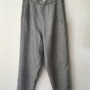 May include: Gray high-waisted pants with a button closure and side pockets.