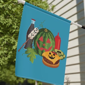 Könnte beinhalten: Eine blaue Flagge mit einer Wassermelone, einem Hamburger, einer Flasche Limonade und einem Marshmallow-Spieß. Die Wassermelone und der Hamburger haben Jack-o'-Lantern-Gesichter.