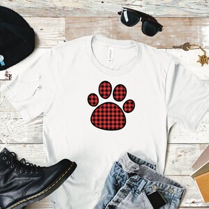 Peut inclure: T-shirt blanc avec un motif d'empreinte de patte en tissu &eacute;cossais rouge et noir.