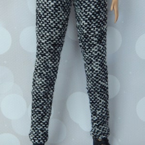 May include: Black and white patterned pants with a tweed-like texture. The pants are fitted and have a straight leg.