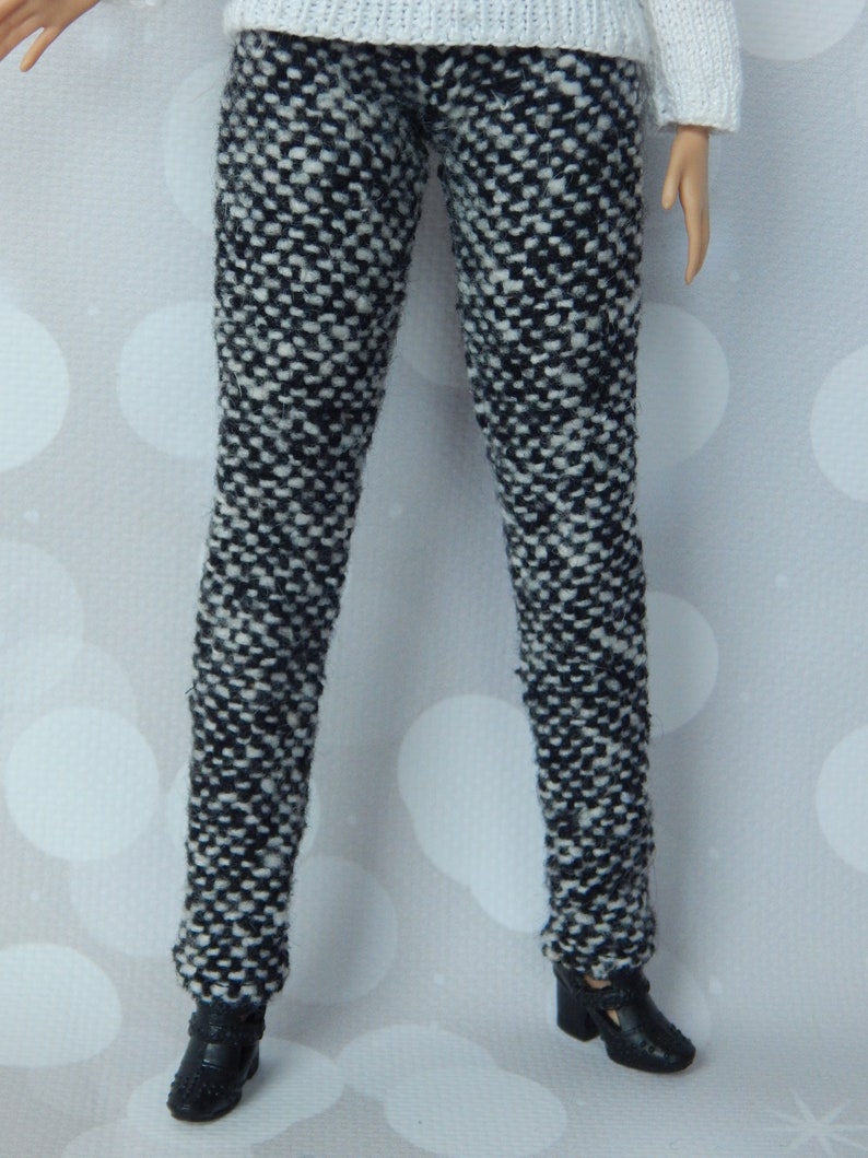 May include: Black and white patterned pants with a tweed-like texture. The pants are fitted and have a straight leg.