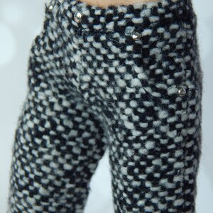 May include: Black and white tweed pants with silver button accents.