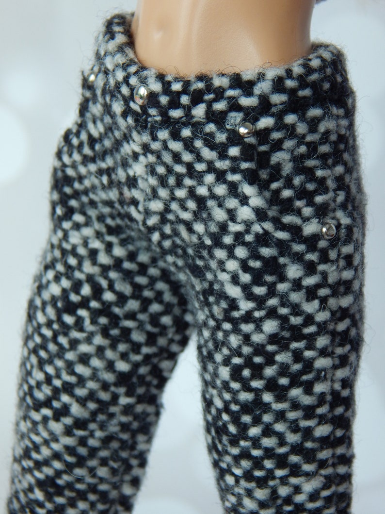 May include: Black and white tweed pants with silver button accents.