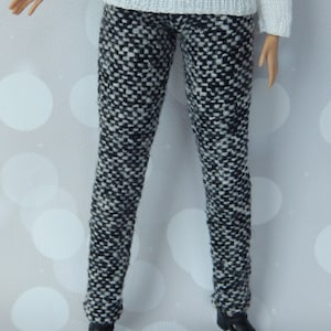 May include: Black and white patterned pants with a white sweater.