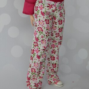 May include: White pants with a pink floral pattern and a red waistband. The pants are made of a soft, comfortable fabric and have a relaxed fit.