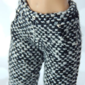 May include: Black and white checkered pants with silver studs. The pants are made of a soft, fuzzy material.