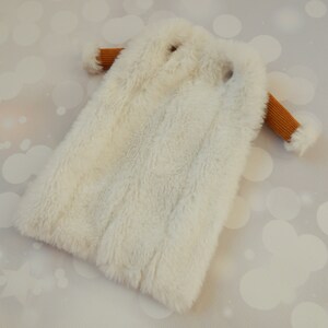 May include: A white faux fur coat with brown ribbed sleeves.