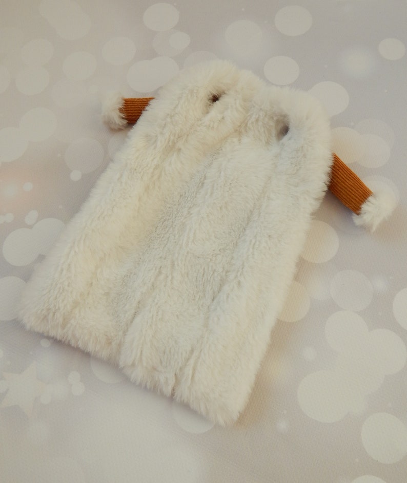 May include: A white faux fur coat with brown ribbed sleeves.