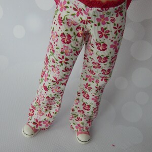 May include: White pants with a pink floral pattern and a red waistband. The pants are made of a soft, comfortable fabric and have a relaxed fit.