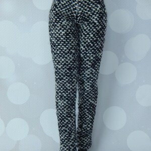 May include: Black and white patterned pants with a high waist and a slim fit.