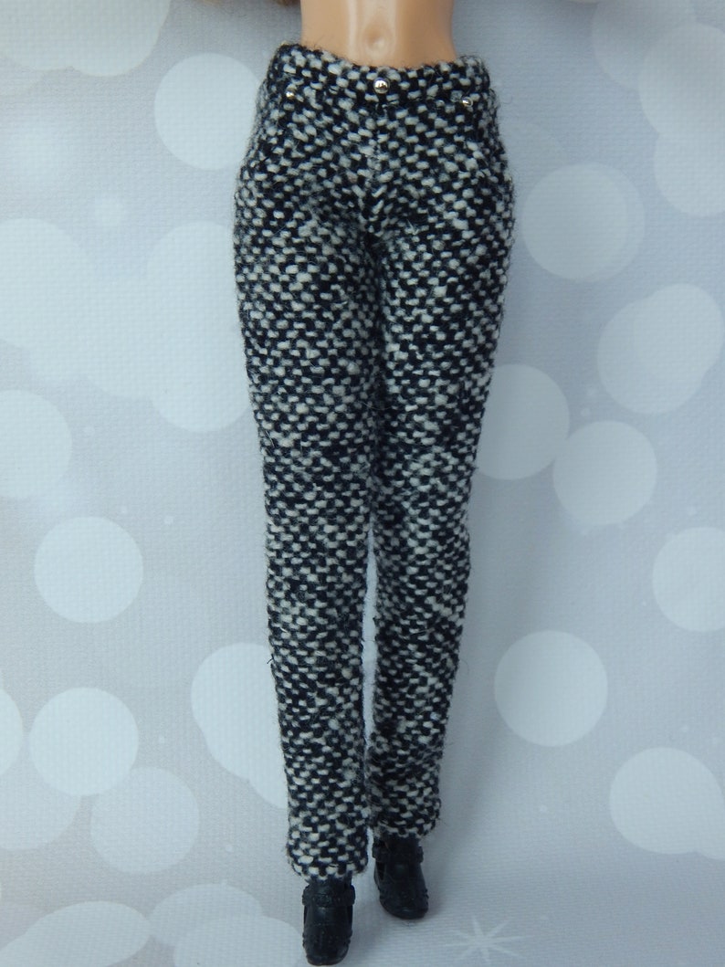 May include: Black and white patterned pants with a high waist and a slim fit.