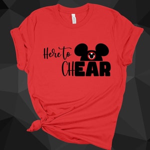 May include: Red t-shirt with a black Mickey Mouse head and the text "Here to Cheer" in black.