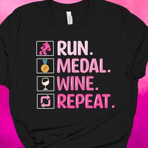 May include: Black t-shirt with the words "RUN. MEDAL. WINE. REPEAT." in pink, with corresponding icons. The shirt features a running figure, a medal, a wine glass, and a repeat symbol.