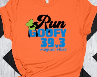 May include: Orange t-shirt with a black and green cartoon character wearing a hat. The text "Run Goofy 39.3 magical miles" is printed on the shirt.