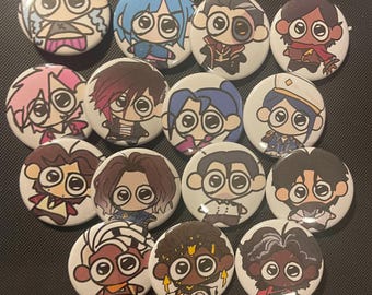 May include: A set of 14 round button pins featuring cartoon characters with large eyes. The characters are drawn in a variety of styles and colors, including blue, red, pink, black, and white.
