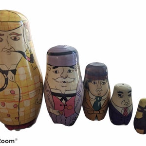 May include: A set of five wooden nesting dolls, or matryoshka dolls, featuring cartoon characters. The largest doll is a man with a yellow and white checkered jacket, a magnifying glass, and a pipe. The other dolls are also men, each with a different outfit and facial expression. The smallest doll is a black cat.