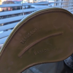Pu&ograve; includere: Una pirofila in ceramica verde con le parole "BEAUCEWARE CANADA" stampate sul fondo.