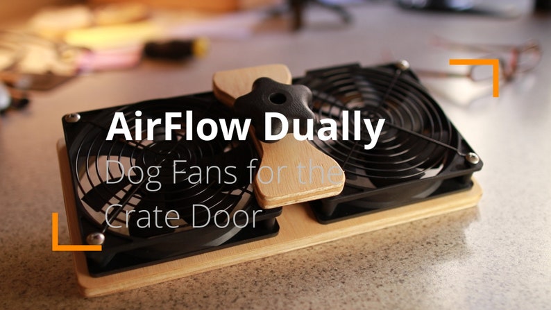 May include: A dual fan system for dog crates, labeled "AirFlow Dually." The system features two black fans with protective grilles, mounted on a wooden base. A wooden handle is attached to the top. Text on the image reads "Dog Fans for the Crate Door."