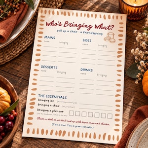 May include: A cream-colored paper sign with a brown dash border titled Who's Bringing What? pull up a chair - a friendsgiving. It features sections for Mains, Sides, Desserts, Drinks, and The Essentials with lines for names and items to bring.