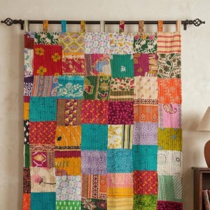 Puede incluir: Una cortina de patchwork con una variedad de cuadrados de tela coloridos. La cortina está colgada de una barra decorativa. Los cuadrados presentan patrones florales y geométricos en tonos de rojo, azul, verde y amarillo. Un elemento de decoración del hogar.