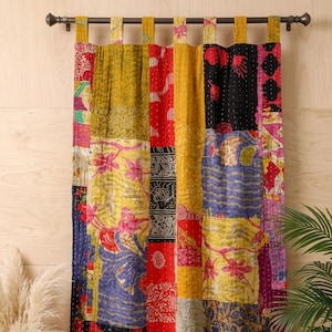 May include: A patchwork curtain with a variety of colorful fabric squares. The curtain features a mix of floral and geometric patterns in shades of yellow, red, blue, and black. It is hung on a dark brown rod.