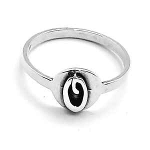 Puede incluir: Un anillo de plata con un diseño ovalado simple. El óvalo contiene una pequeña letra 'O' estilizada en su interior.