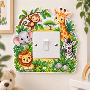 May include: A white single-toggle light switch plate featuring a colourful jungle scene with a cartoon giraffe, elephant, lion, zebra, and monkey surrounded by green foliage, small white flowers, and a blue bird against a savanna background.