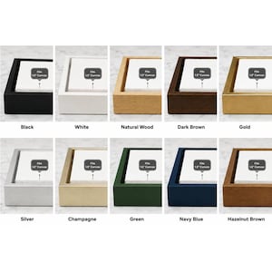 Könnte beinhalten: Eine Sammlung von zehn rechteckigen Schattenfugenrahmen in Schwarz, Weiß, Naturholz, Dunkelbraun, Gold, Silber, Champagner, Grün, Marineblau und Haselnussbraun. Jeder Rahmen enthält einen weißen Einsatz mit dem Text Fits 3.8 cm Canvas.