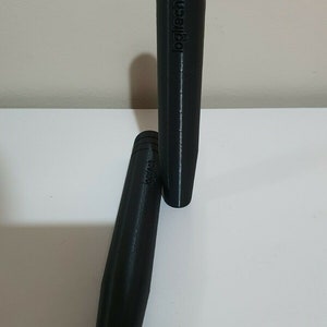 May include: Two black Logitech branded cylindrical shaped controllers.