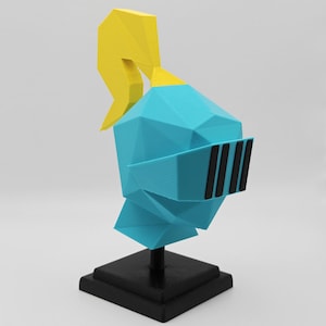 May include: A low-poly style knight helmet figurine in bright blue with a yellow plume on top and a black visor with three vertical slits. The helmet is mounted on a black square base with a central support post, creating a geometric display piece.