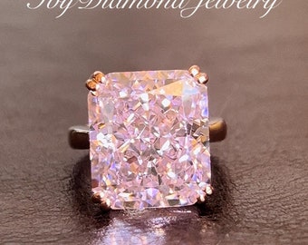 May include: A rose gold ring with a large, square-shaped, pink diamond.
