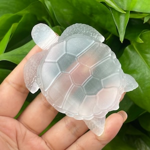 May include: A clear glass sea turtle figurine with a detailed shell design.