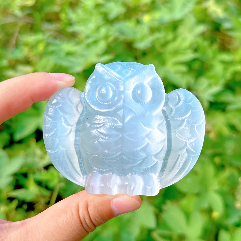 K&ouml;nnte beinhalten: Eine hellblaue Glas-Eulenfigur mit detaillierten Fl&uuml;geln und Augen. Die Eule ist mit einer strukturierten Oberfl&auml;che geschnitzt.