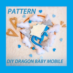 May include: DIY pattern for a baby mobile featuring a blue felt dragon, white clouds, gray mountains, and wooden hearts. The pattern includes the text "PATTERN" and "DIY DRAGON BABY MOBILE".
