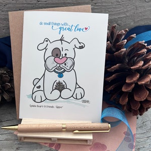 May include: A white card with a cartoon illustration of a dog with a pine cone. The card says "do small things with great love" and "Spinkie Bear & Friends: 'Gipper'".