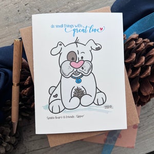 May include: A white card with a cartoon illustration of a white dog with brown spots holding a pine cone. The card has the text "do small things with great love" and "Spinkie Bear & Friends: 'Gipper'".