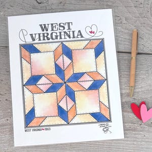 May include: A printed sheet featuring a West Virginia quilt block design with blue, peach, and cream geometric shapes. The text WEST VIRGINIA appears at the top with a heart icon, and WEST VIRGINIA 1863 is printed at the bottom corner.