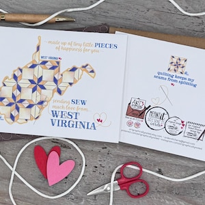 May include: A white card with a blue and yellow quilt pattern of the state of West Virginia. The card says "made up of tiny little pieces of happiness for you" and "sending sew much love from... West Virginia". The back of the card has a brown envelope with the text "quilting keeps my seams from splitting".