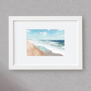 Riflesso del cielo azzurro su una spiaggia soleggiata e bagnata, dipinto ad acquerello originale.