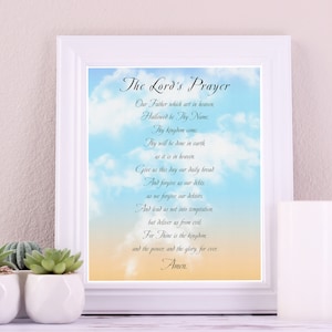 Puede incluir: Una impresión enmarcada en blanco con un fondo nublado azul y amarillo que presenta la oración del Señor en texto negro.