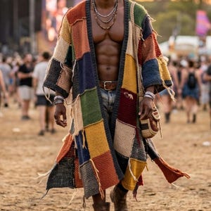 May include: A long, patchwork cardigan in various colors, including red, blue, green, and yellow. The cardigan is worn open, revealing a belt and jeans. The person is wearing sunglasses and boots, walking in a crowd.
