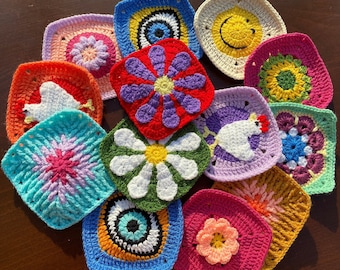 May include: A collection of colorful, square crochet coasters. Designs include flowers, a smiling sun, an eye, and other geometric patterns. The coasters are made with various colors of yarn, including red, blue, yellow, and green.