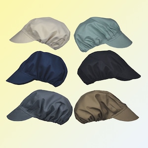 May include: Six fabric caps in assorted colours: beige, teal, navy blue, black, grey, and brown. Each cap has a peak and a gathered back, offering a classic, functional design. The caps are arranged against a gradient yellow background.