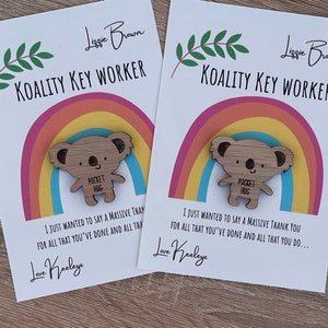 May include: Two cards with a rainbow design and a wooden koala keychain with the text "Pocket Hug" on it. The cards say "Koality Key Worker" and "I just wanted to say a massive thank you for all that you've done and all that you do... Love Keeleye".