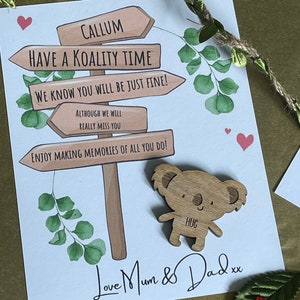 May include: A card with a wooden signpost with the text "Callum Have a Koality Time We Know You Will Be Just Fine! Although We Will Really Miss You Enjoy Making Memories Of All You Do!" and a wooden koala cutout with the text "Hug". The card has a green leafy background and the text "Love Mum & Dad xx" at the bottom.